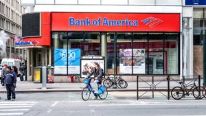 Street view on Bank of America branch in NYC with people waiting, pedestrians crossing, crosswalk, bike, road in Manhattan