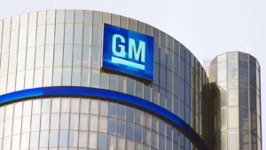 Image of General Motors logo on corporate building with clear sky in the background.