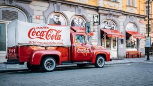 Image of a red Coca-Cola (KO) truck on a city street