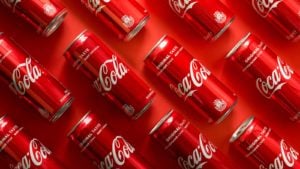 Close-up of Coca Cola beverage cans placed on paper background. KO stock