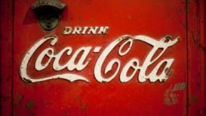 An image of an old red and rusted fridge door with a metal 