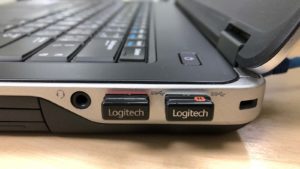Two receivers for wireless Logitech (LOGI) devices, plugged into a laptop computer.