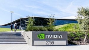 Nvdia (NVDA) のオフィスビル。正面にライム グリーンのロゴが入っています。 緑の芝生と澄んだ空が見える..