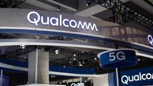 Λογότυπο Qualcomm (QCOM) σε μια μεγάλη πινακίδα με μια άλλη πινακίδα που λέει 5G