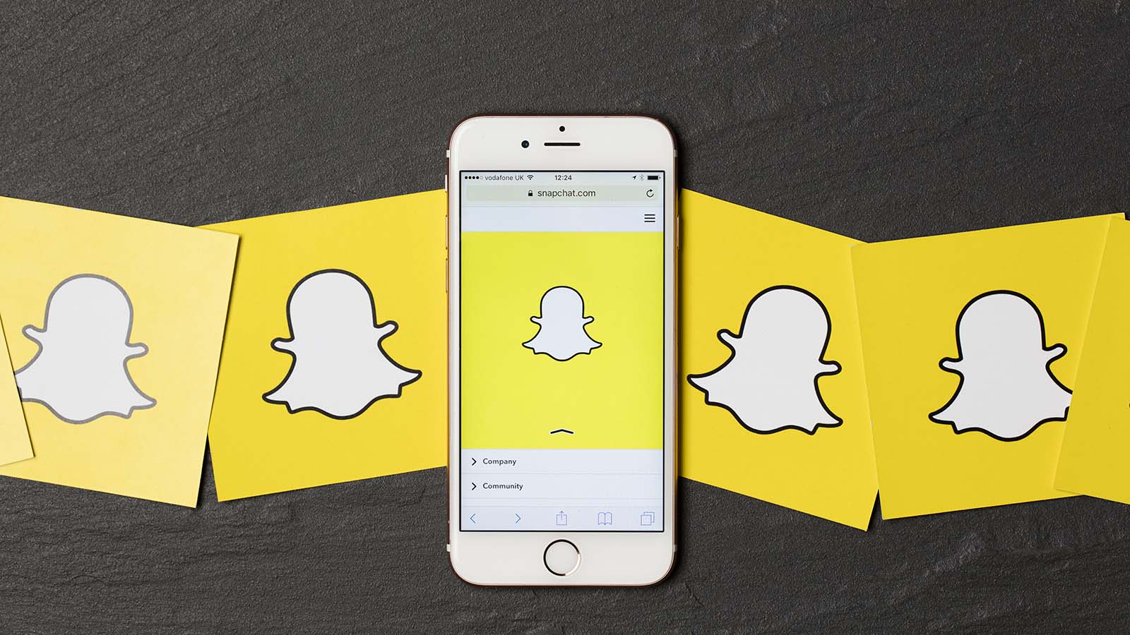 An apple iPhone showing the snapchat (SNAP) application alongside other snapchat logos
