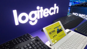 logitech (LOGI) logo behind a desk with laptops on it representing tech stocks