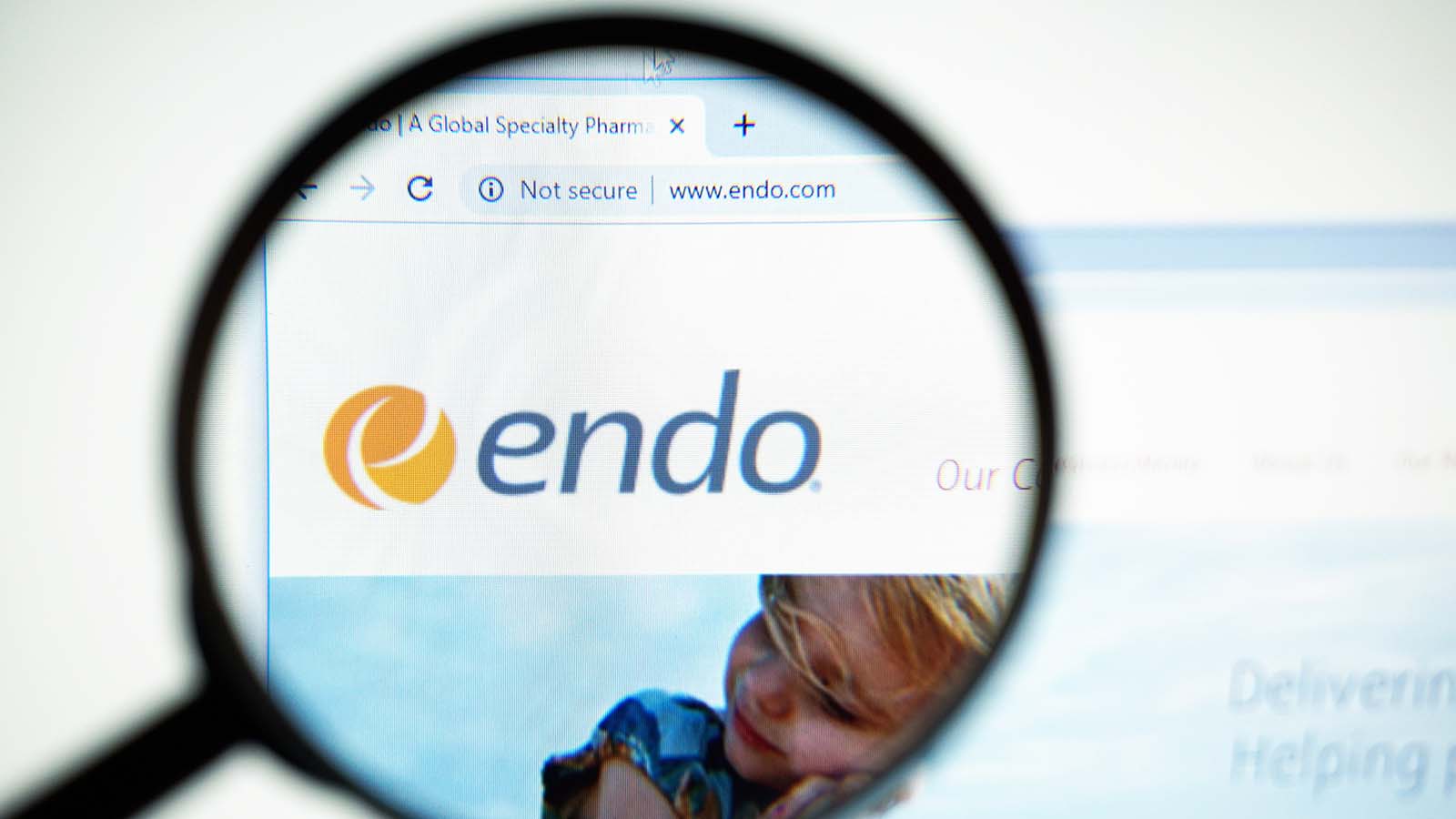 A magnifying glass zooms in on the logo for Endo International PLC (ENDP)