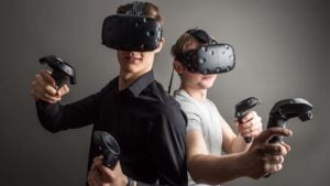 Απόθεμα IMMR: δύο άτομα που χρησιμοποιούν ακουστικά εικονικής πραγματικότητας (VR).