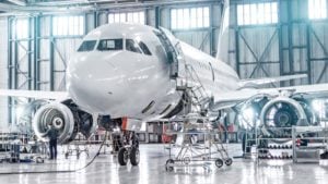 a private plane inside a hangar is prepared for a flight. represent aerospace stocks. Safe Dividend Stocks