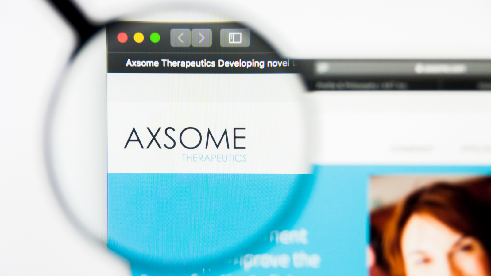 A magnifying glass zooms in on the Axsome Therapeutics, Inc. (AXSM Stock) logo