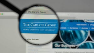 A magnifying glass zooms in on the Carlyle Group, Inc. (CG) logo