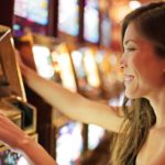 a woman smiling while using a slot machine in a casino. representing gambling stocks