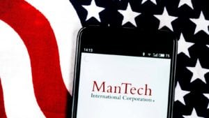 Mantech (MANT) logo displayed on a mobile phone with the American flag in the background