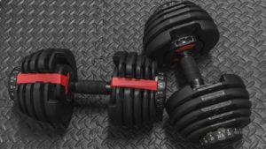 two black and red dumbbels sit on the floor