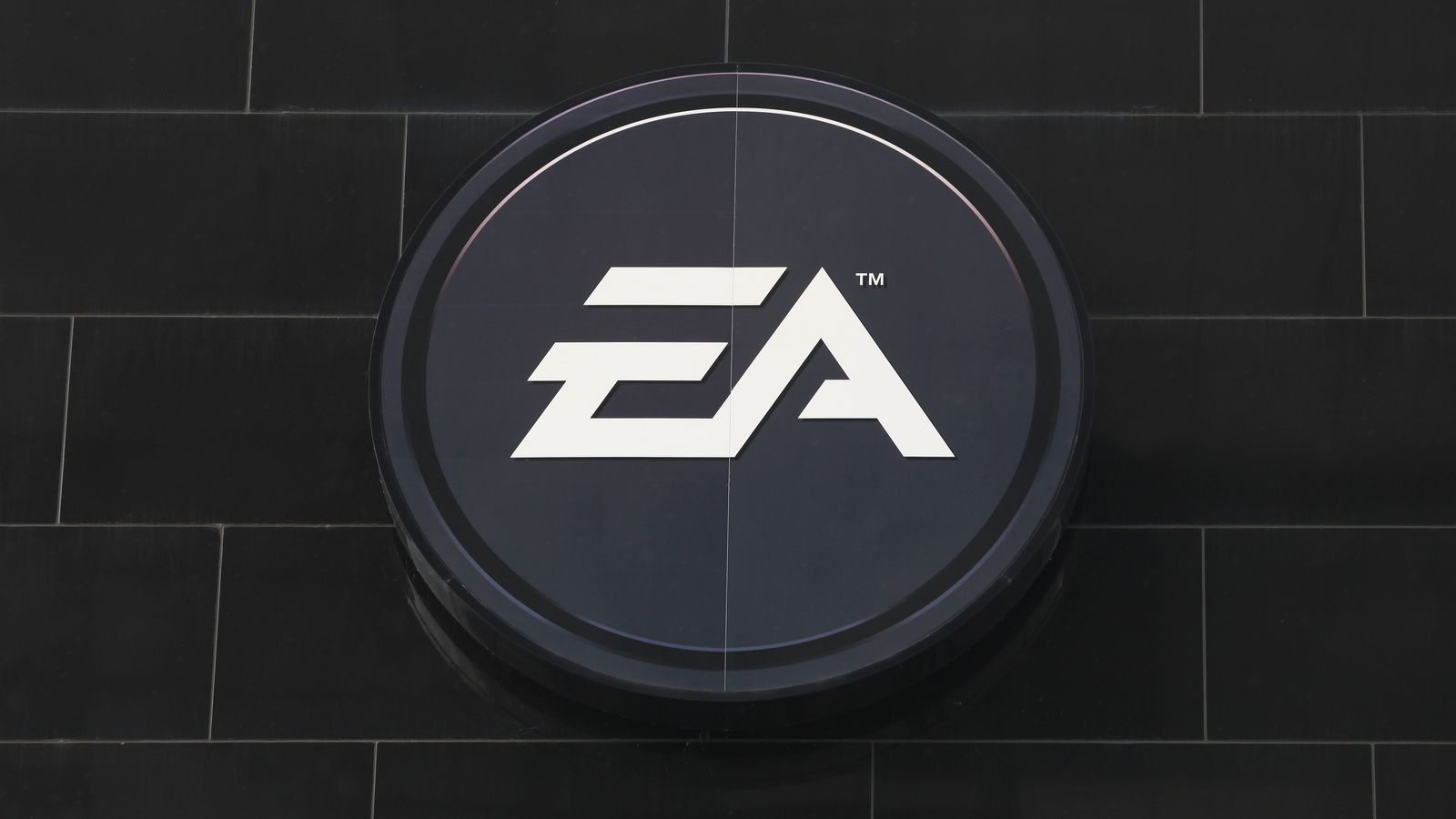 Image of Electronic Arts (EA stock) logo on a dark grey brick wall