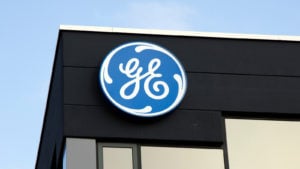 Image of General Electric (GE) logo on the top of a corporate building with clear blue sky in the background.