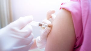 image of person injecting vaccine into an arm. short-term stocks