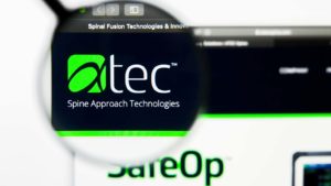A magnifying glass zooms in on the Alphatec Holdings, Inc. (ATEC) logo