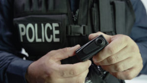 An image of a police officer holding a body camera