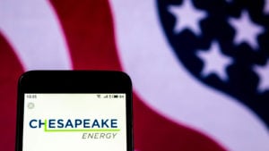 Chesapeake Energy (CHK) logo displayed on phone with American flag in background