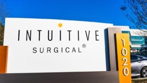 A sign with the Intuitive Surgical logo standing outside of a company office