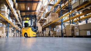 Image of a man driving a forklift in a warehouse.