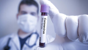 Image of a doctor holding a vial labeled as coronavirus.