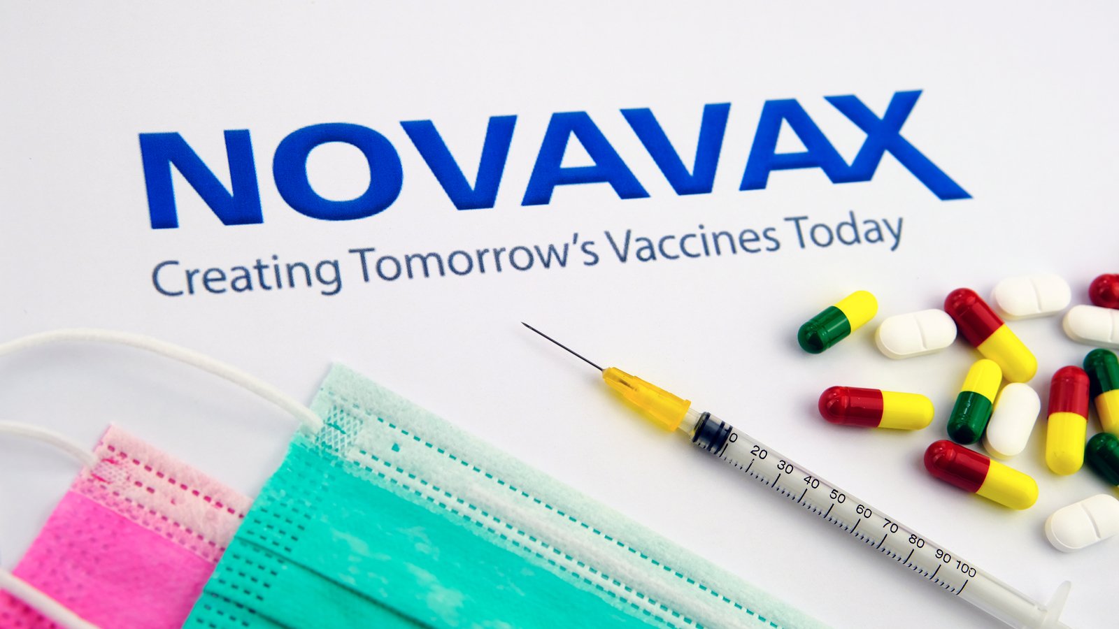 Novavax (NVAX) logo surrounded by medical supplies