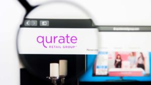 A magnifying glass zooms in on the Qurate Retail, Inc. (QRTEA) logo