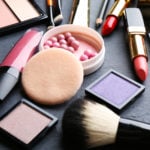 a collection of various cosmetic products on a black table