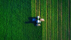 a tractor cultivating a farm from an aerial view representing FAMI Stock.