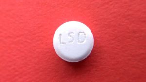 A photo of a white pill with LSD on it