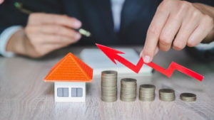 a stack of coins and red arrow pointing up to a house figure to represent crowdfunding real estate