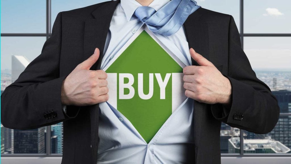 A businessman ripping his shirt off to reveal an upward green arrow with the word buy on it underneath