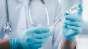 hands of medical professional holding a vaccine syringe