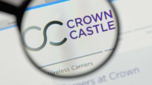 Image du logo Crown Castle (CCI) sur un navigateur Web mis en évidence à travers la lentille d'une loupe