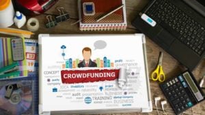 an image of the words crowdfunding on a tablet on a table. invest in startups