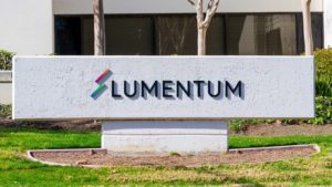Image of Lumentum (LITE) logo out front of a grey corporate building