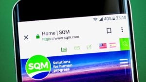 Sociedad Quimica y Minera (SQM) logo displayed on a mobile phone with the company's web page on it