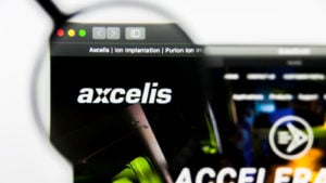 虫眼鏡のレンズを通して拡大された Web ブラウザ上の Axcelis (ACLS) ロゴの画像