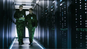 military members walking in a server room representing What Stocks to Buy During War.