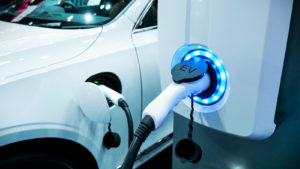 an electric car plugged in for charging, representing electric RMO stock.