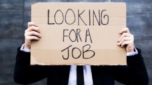 Man holding sign that reads "Looking for a job"
