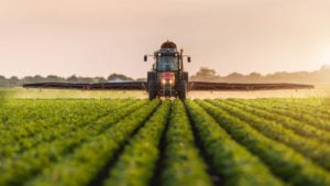 FAMI stock: Tractor spraying pesticides on soybean field with sprayer