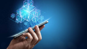 An image of a hand holding a mobile phone with multiple views of digital building blocks floating above it.  representing I'm platforms