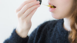 Woman Taking CBD Oil Under Tongue