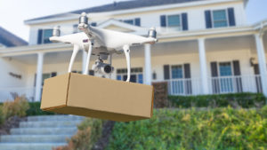 Image of a drone delivering a package to a home.