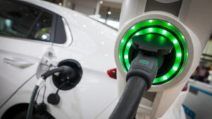 an electric vehicle (EV) at a charging station representing NAKD Stock.