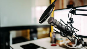 A close-up image of a microphone in a podcast studio.