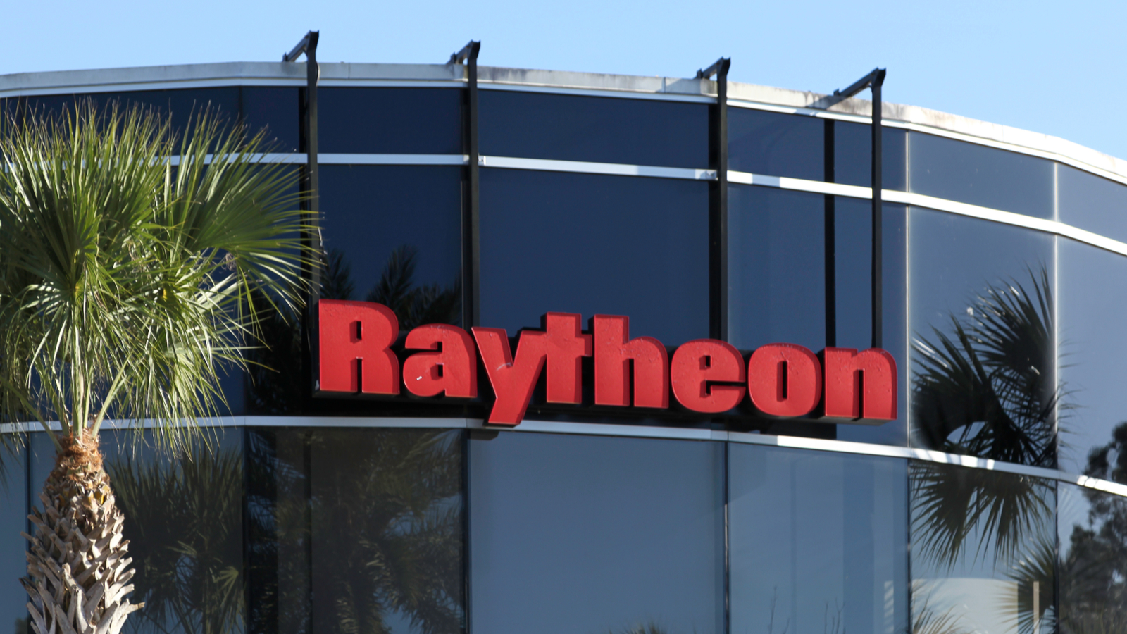 Raytheon (RTX) defense company logo hanging from glass building